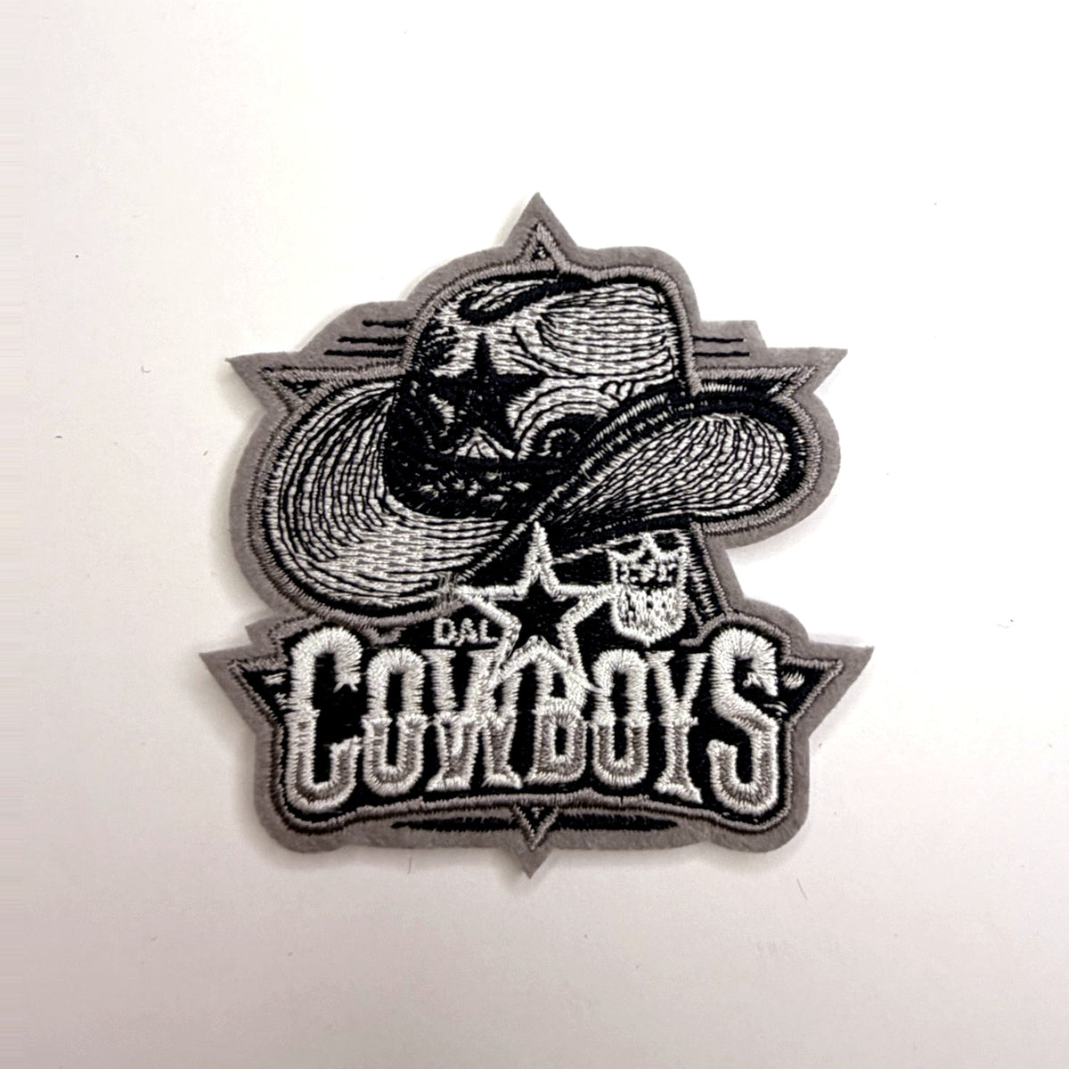 Gray cowboy hat and skull patch with lettering